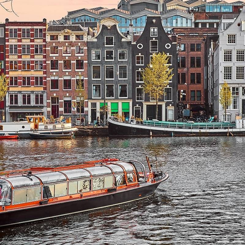 Enchanting Travels European Capitals ToursChannel in Amsterdam Netherlands houses river Amstel landmark old european city spring landscape.