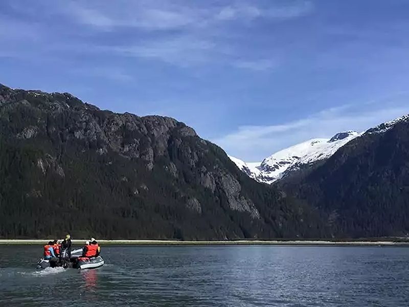 Travelers enjoying scenic views from a skiff in Alaska