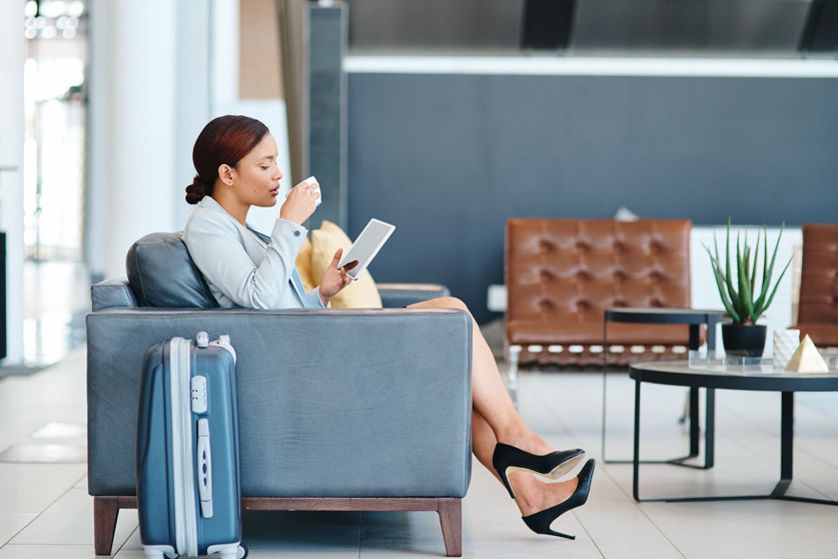 Woman enjoying her coffee using airport lounge access credit card